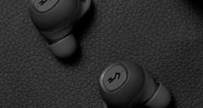 YX1 earphones laid on a leather surface.