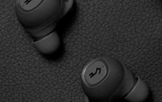 YX1 earphones laid on a leather surface.