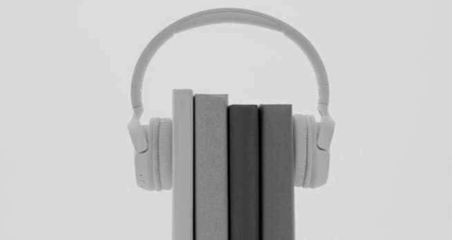 XX59 headphones wrapped around a stack of books.