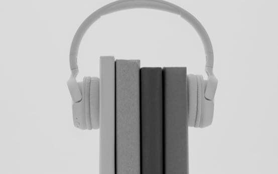 XX59 headphones wrapped around a stack of books.